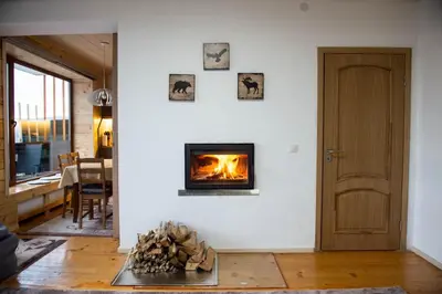 a living room with a fireplace and a wooden door at Sapareva Kashta in Sapareva Banya