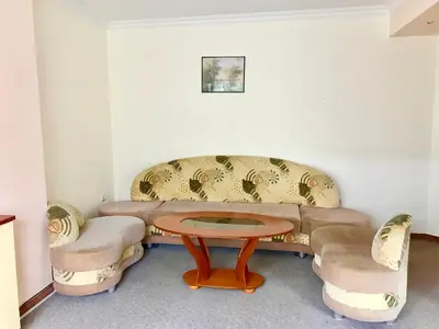 a living room with a couch and a table and chairs at Daf Trans Hotel in Peshtera