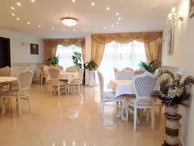 a dining room with tables and chairs and windows at Hotel Dalia - Bankya in Bankya