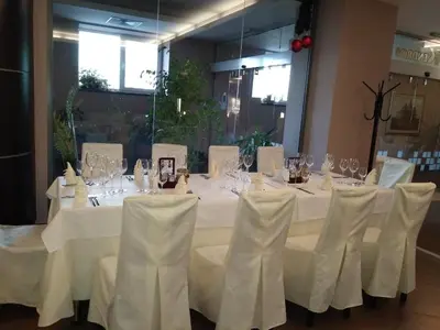 a table with white table cloths and wine glasses at Kendros Hotel in Plovdiv