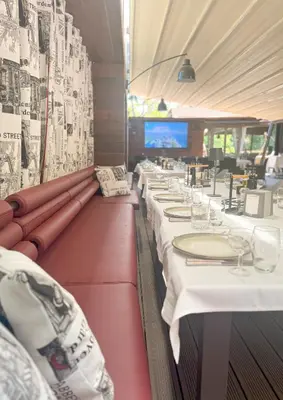 a row of tables in a restaurant with white table settings at Family Hotel EDI in Sofia