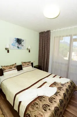 a bedroom with a large bed with a large window at Guesthouse Nefertiti in Smolyan