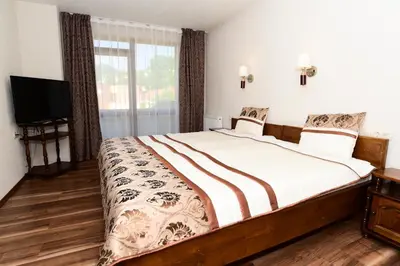 a bedroom with a large bed and a television at Guesthouse Nefertiti in Smolyan