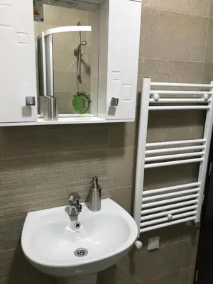 a bathroom with a white sink and a mirror at Apartment Trimontium in Plovdiv