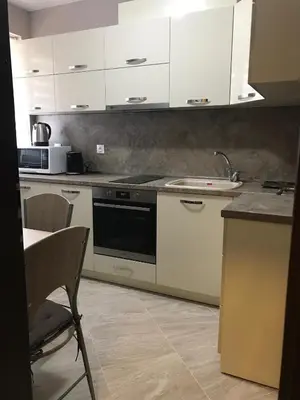 a kitchen with white cabinets and a stove top oven at Apartment Trimontium in Plovdiv