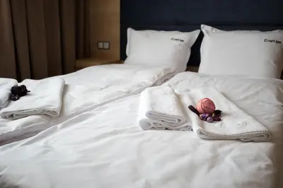 a white bed with towels and flowers on it at Court Inn in Panagyurishte