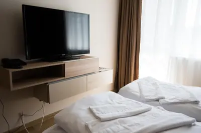 a hotel room with a flat screen tv and towels at Court Inn in Panagyurishte
