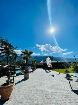 a patio with palm trees and the sun in the sky at Комплекс язовир Валтата Komplex yazovir VALTATA in Samuilovo