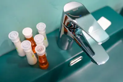 a counter with several bottles of medicine next to a sink at Комплекс язовир Валтата Komplex yazovir VALTATA in Samuilovo