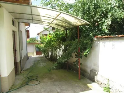 a patio with a canopy with a tree next to a building at Guest House Vergie, Fully Private in Sapareva Banya