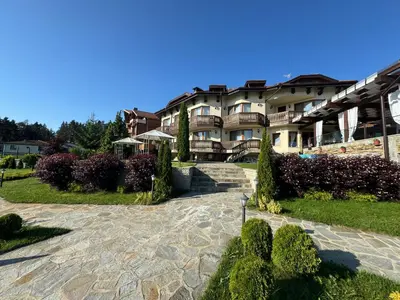 a large apartment building with a stone walkway at Family Hotel Eterno in Tsigov Chark