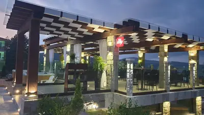 a restaurant with a pergola with tables and chairs at Family Hotel Eterno in Tsigov Chark