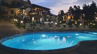 a swimming pool at a resort at night at Family Hotel Eterno in Tsigov Chark