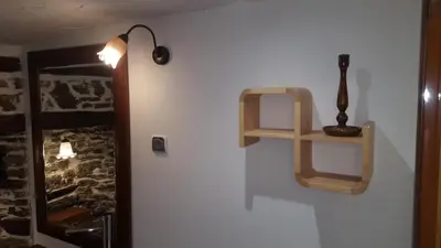 a white wall with a shelf and a lamp on it at Pisanata House in Dedovo