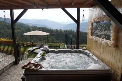 a hot tub on a patio with a view of mountains at Planinski Polah House in Devin
