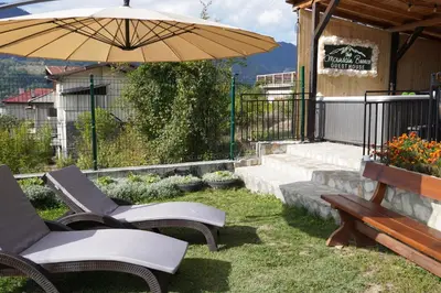 a patio with two chairs and an umbrella at Planinski Polah House in Devin