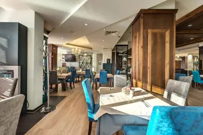 a dining room with blue chairs and tables at Belvedere Holiday Club in Bansko
