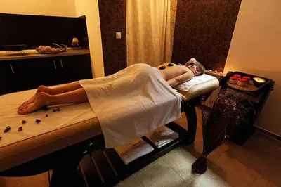 a woman laying on a bed in a room at Belvedere Holiday Club in Bansko