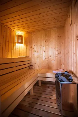 a wooden sauna with a bench and a light in it at Guest House Holiday in Ognyanovo