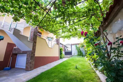 an internal courtyard of a house with a green yard at Guest House Holiday in Ognyanovo