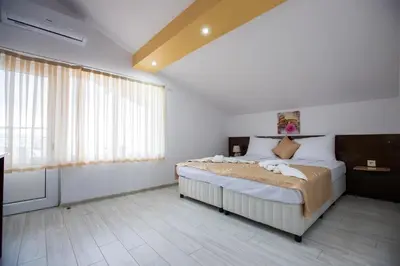 a bedroom with a bed and a large window at Guest House Holiday in Ognyanovo