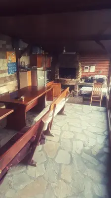 a group of wooden benches sitting in a room at Guest House Holiday in Ognyanovo
