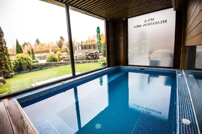 a swimming pool in a building with windows at The Balkan Jewel Resort, Trademark Collection by Wyndham in Bansko