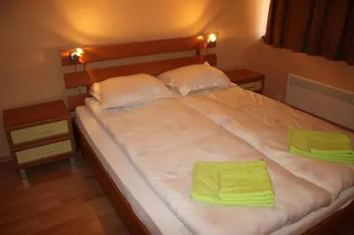 a large bed with two green towels on it at PM Services Sequoia Apartment in Borovets
