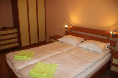 a large bed with two green towels on it at PM Services Sequoia Apartment in Borovets