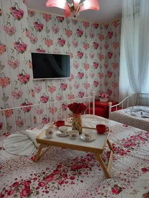 a bedroom with a table with flowers and a tv at Guesthouse Jasmin in Sapareva Banya