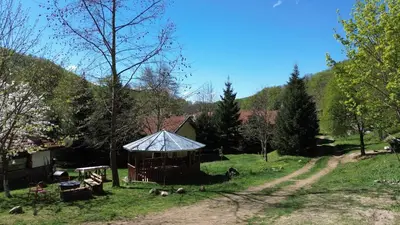 a gazebo in a field next to a dirt road at Бунгала Дара in Kalofer