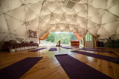 a woman is sitting in a room with purple mats at Бунгала Дара in Kalofer