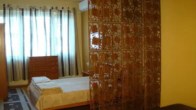 a bedroom with a bed and a large wooden cabinet at Apartment SOFIA Center in Sofia
