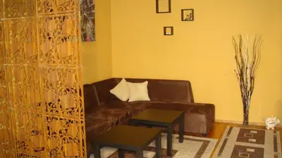 a living room with a brown couch and a table at Apartment SOFIA Center in Sofia