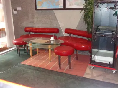a group of red chairs and a table in a room at Kestenite Family Hotel in Samokov