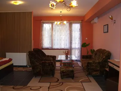 a living room with chairs and a table and a window at Kestenite Family Hotel in Samokov