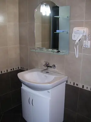 a bathroom with a sink and a mirror at Kestenite Family Hotel in Samokov