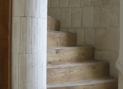 a wooden staircase in a room with a pillar at The Castle Hotel in Samokov