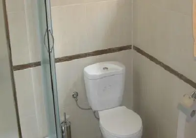 a small bathroom with a toilet and a shower at The Castle Hotel in Samokov