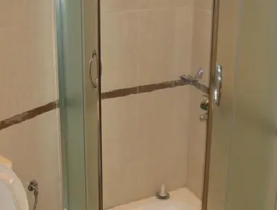 a shower with a glass door next to a toilet at The Castle Hotel in Samokov