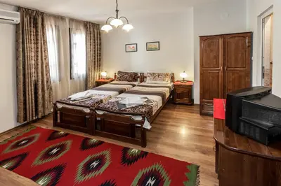 a bedroom with a bed and a tv in it at Keremidchieva Kushta Guest House in Sandanski