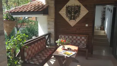 a patio with two benches and a table on a porch at Keremidchieva Kushta Guest House in Sandanski