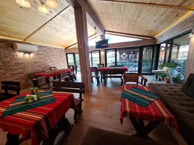 a restaurant with red and green tables and chairs at Keremidchieva Kushta Guest House in Sandanski