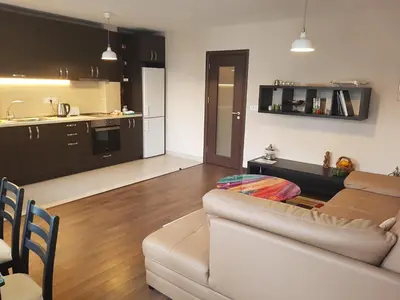 a living room with a couch and a kitchen at Apartments Sofia Yavorov in Sofia