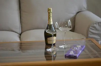 a bottle of champagne and two wine glasses on a table at Apartments Sofia Yavorov in Sofia