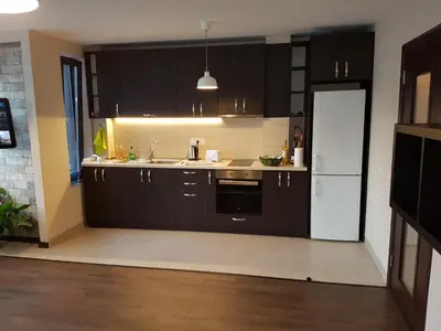 a kitchen with black cabinets and a white refrigerator at Apartments Sofia Yavorov in Sofia