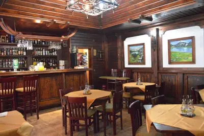 a restaurant with tables and chairs and a bar at Mountain View Resort Studio in Bansko