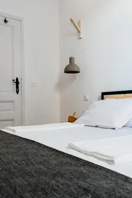 a bedroom with a white bed and a white door at Mouse House Kapana in Plovdiv