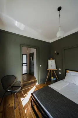 a bedroom with green walls and a bed and a chair at Mouse House Kapana in Plovdiv