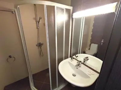 a bathroom with a sink and a shower and a toilet at Nevada Aparthotel in Pamporovo